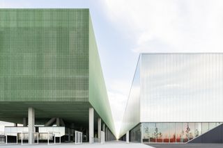 Exhibition complex with two buildings one next to the other. Both are rectangular-shaped. The one to the left is green, and the one to the right is white.