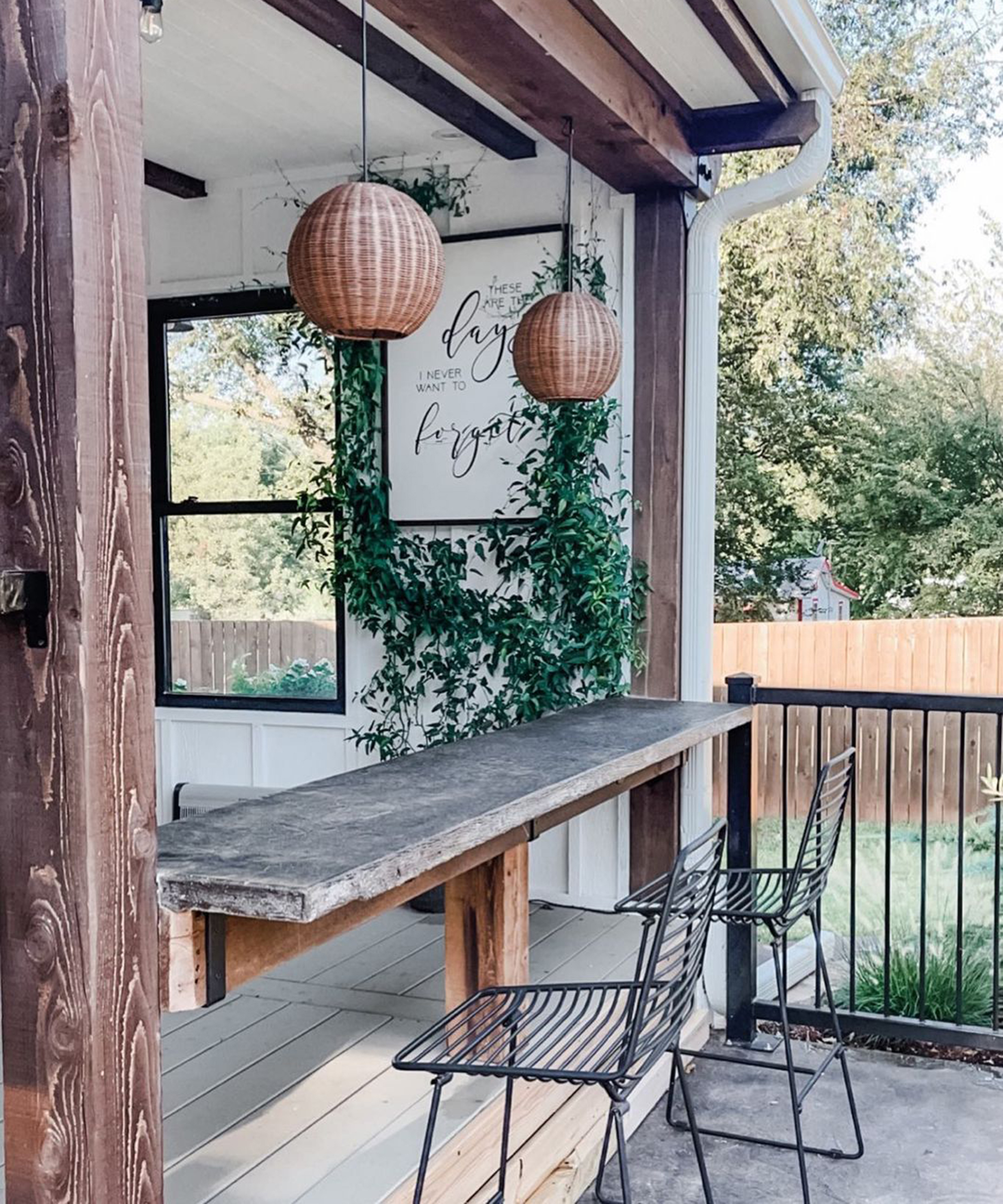 A rustic decking idea with floating table and black chairs by Wayfair