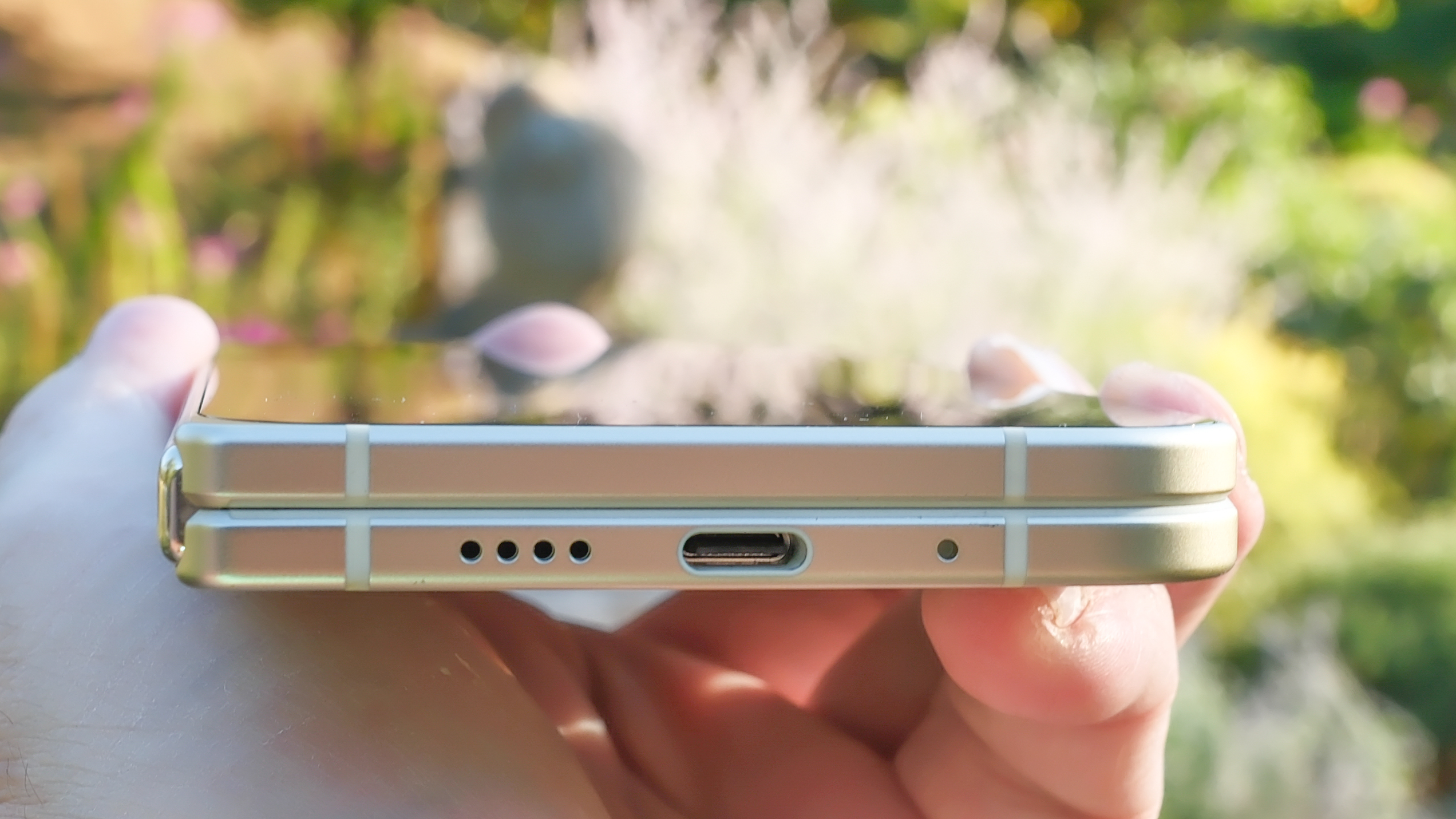 Google Pixel 10 Pro Fold in Jade green outside at a flower garden on a sunny day