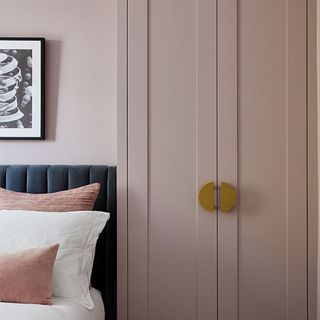 pink bedroom with grey bed and pink cupboard