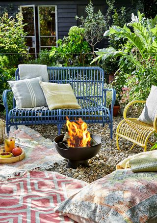 Ignis fire pit in boho setting with colorful garden benches