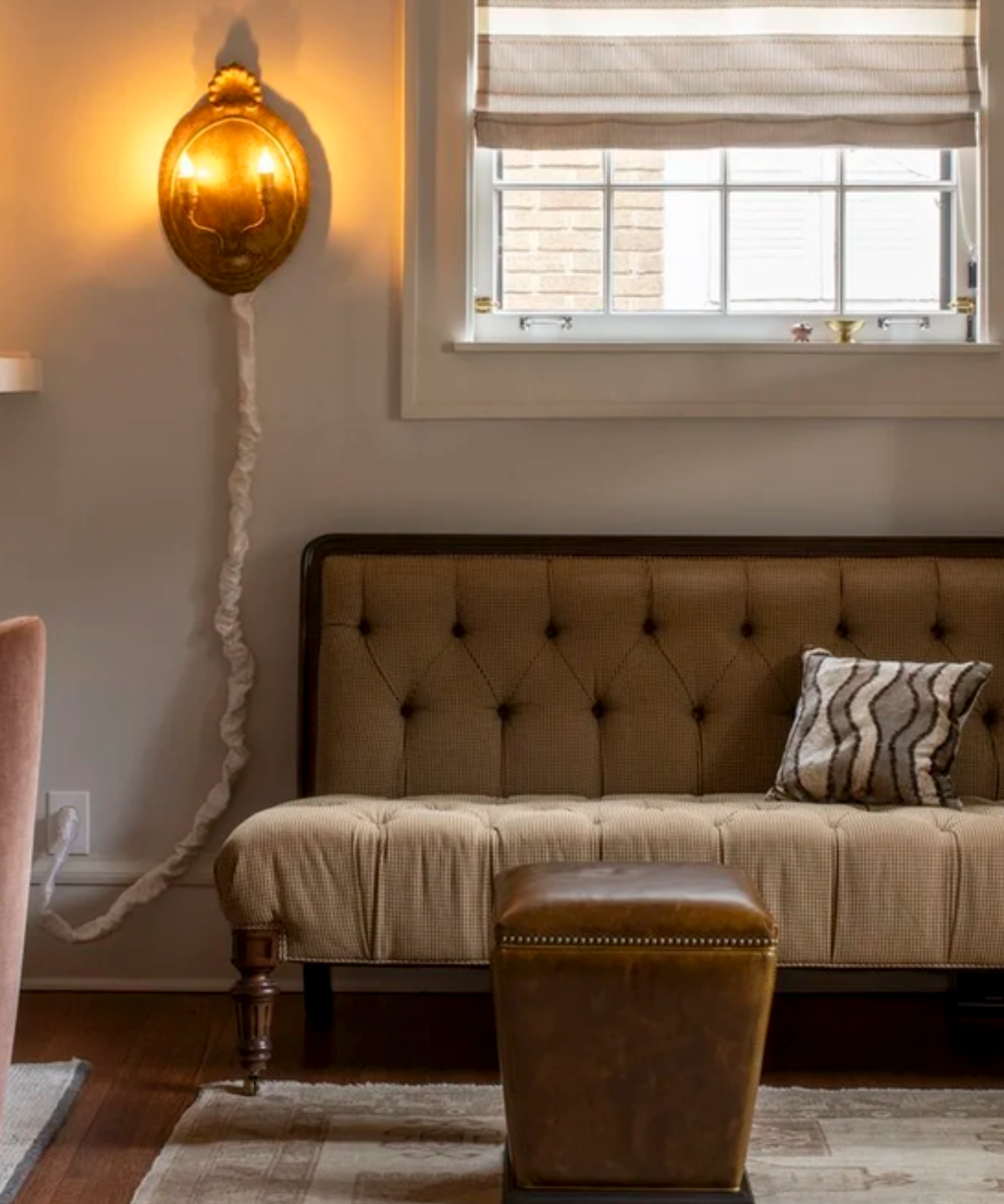 Small vintage sofa sits next to decorative wooden wall light