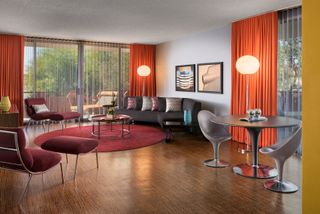 A quirky mid-century modern hotel features boldly colored furniture and sculptural lighting.