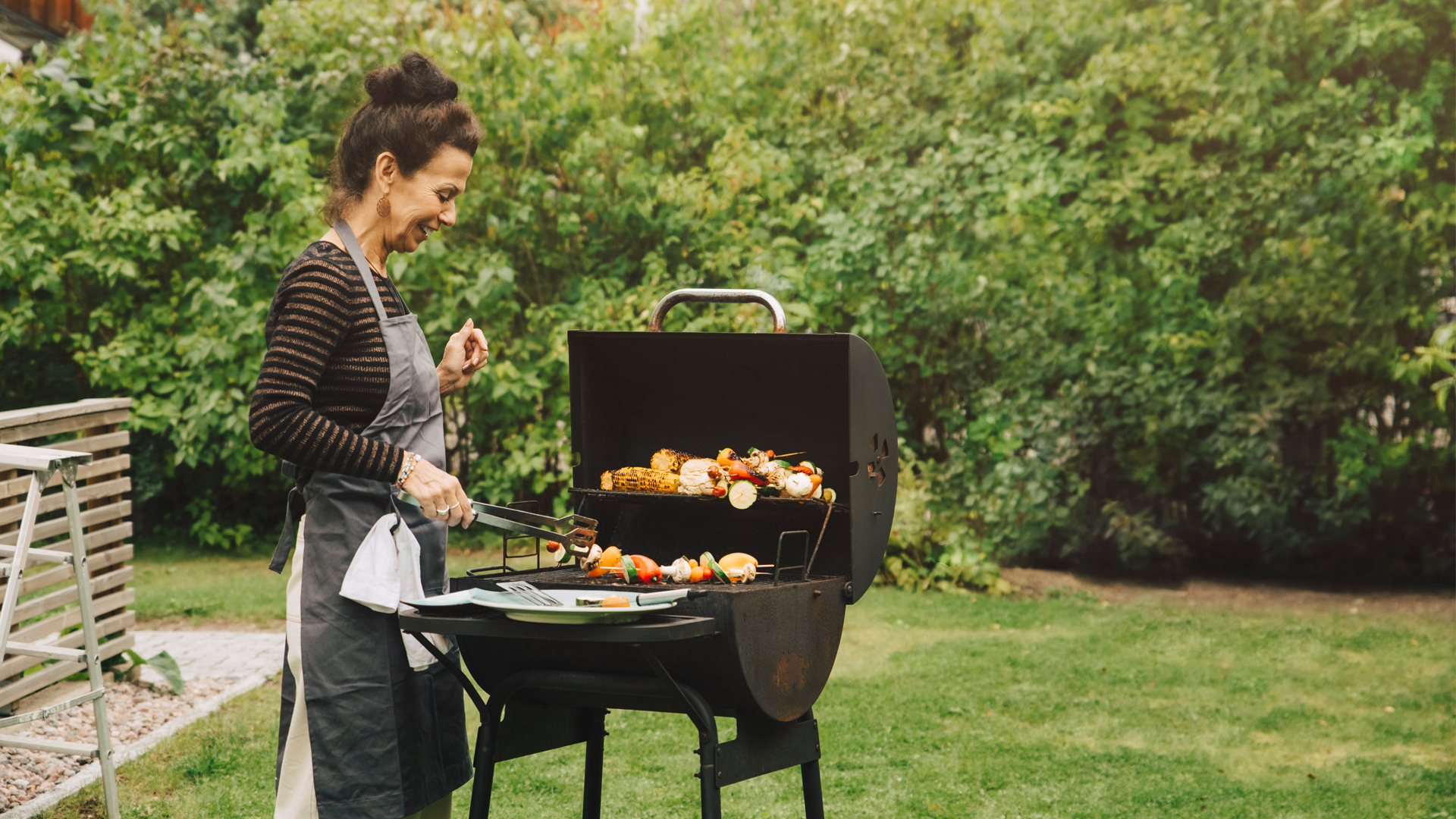 Gas vs charcoal grill: image of woman bbqing