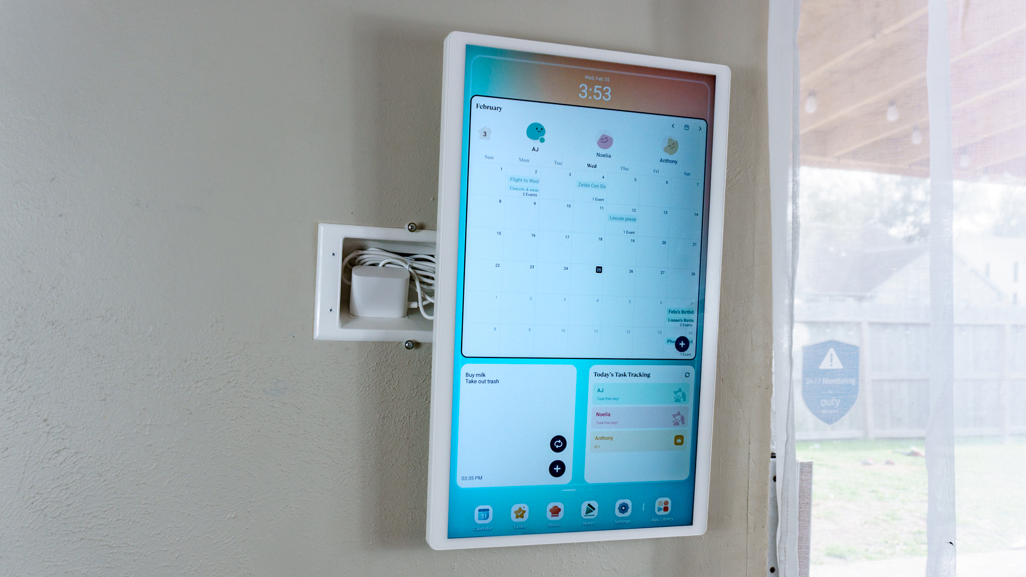 The Cozyla Calendar 2+ mounted on a wall with a recessed outlet behind it to hide its bulky power adapter
