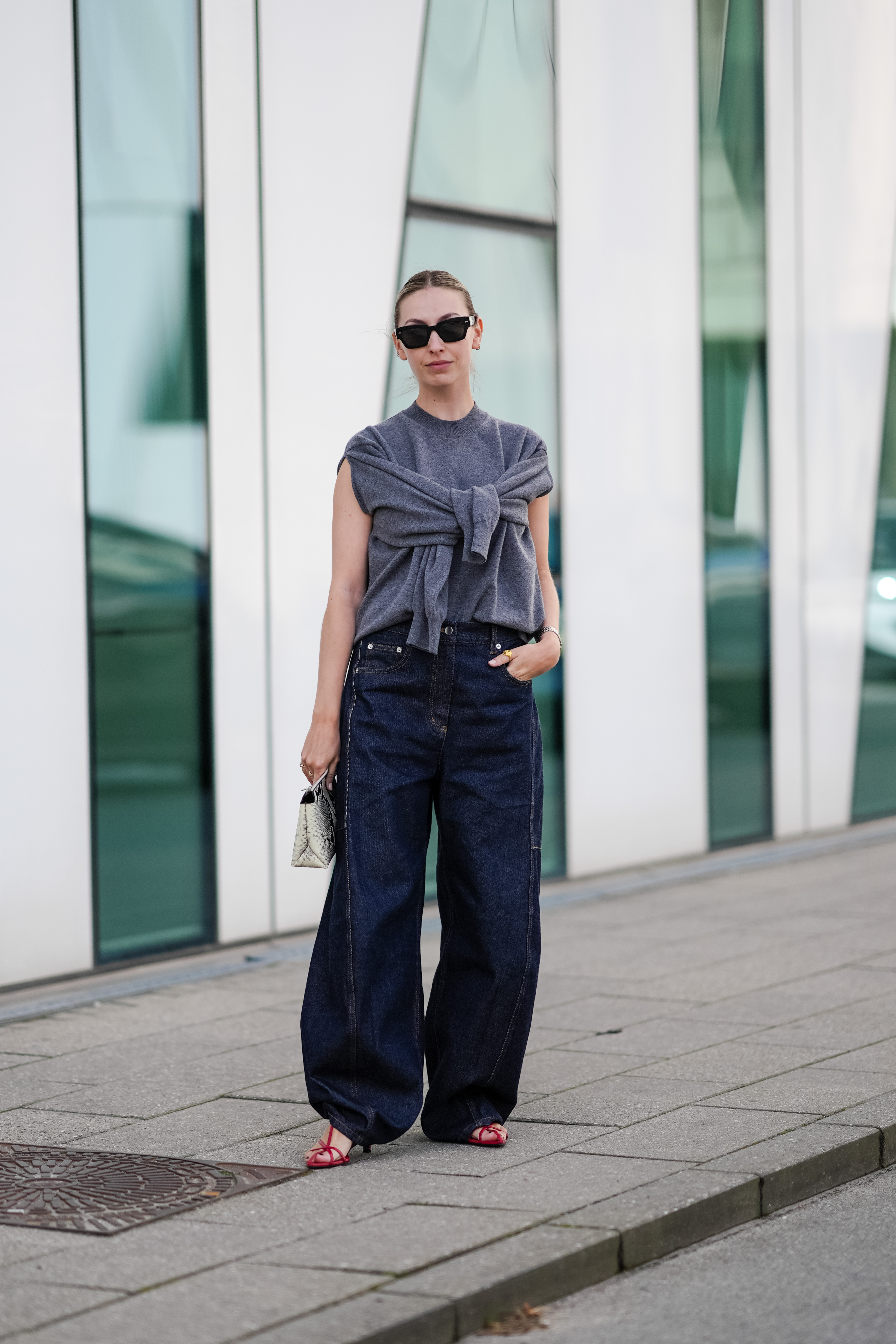 Woman wearing baggy jeans and a sweater vest
