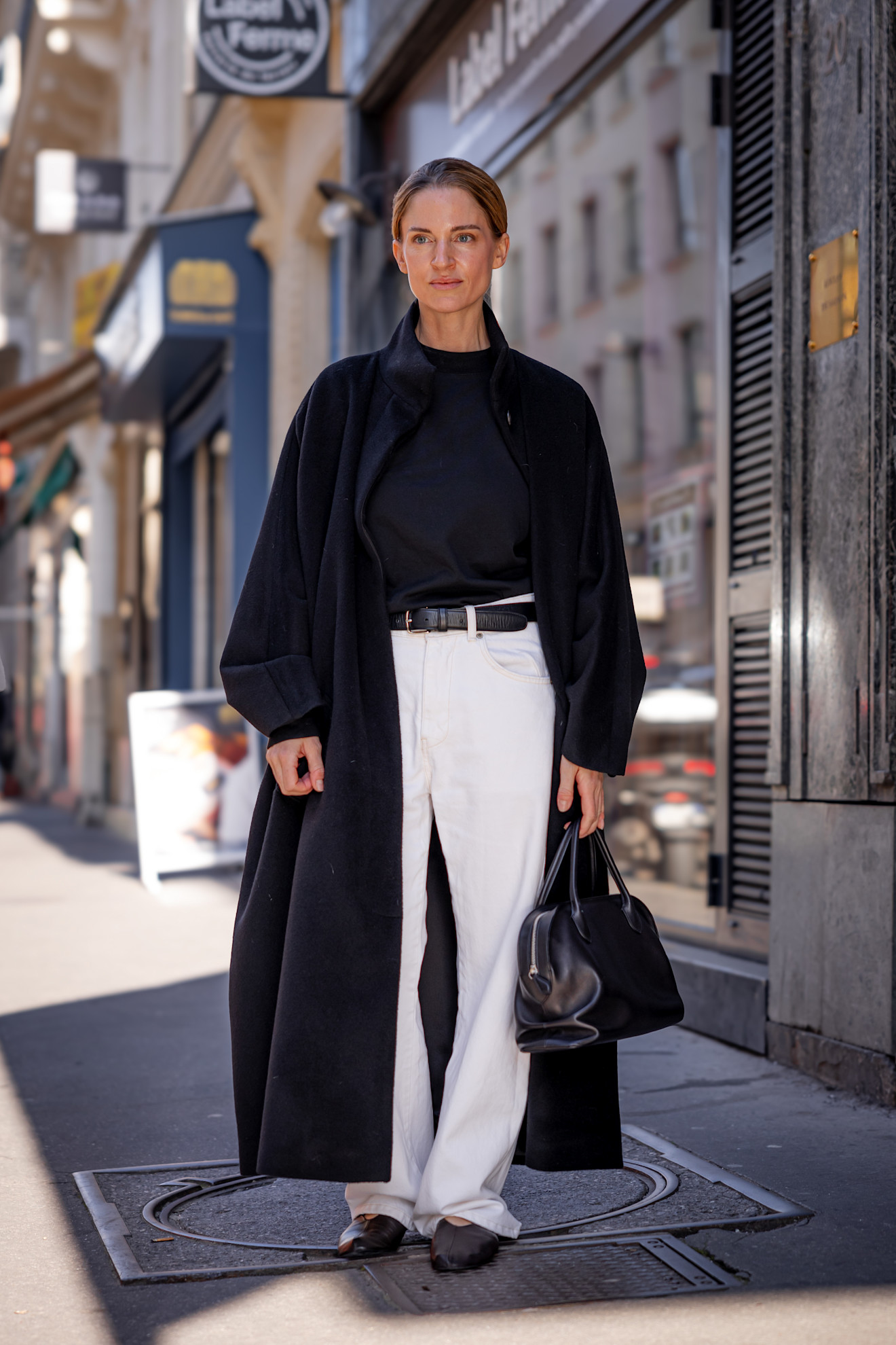 woman wearing white jeans and a navy trench in paris