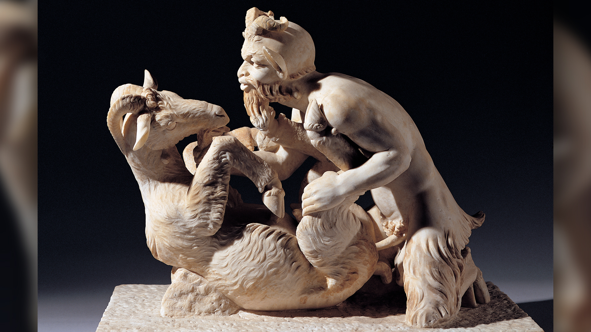 greek god pan squats over a goat sculpture