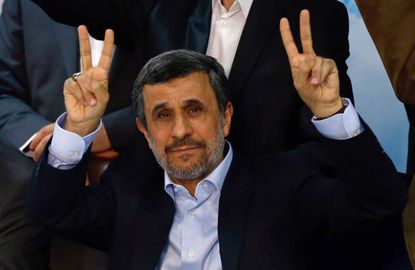 Mahmoud Ahmadinejad raises his hands in V for victory signs