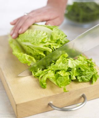 Chopping a romaine lettuce on a wooden board