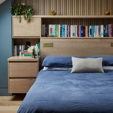 A bedroom with a floating bedside table and a bookcase headboard