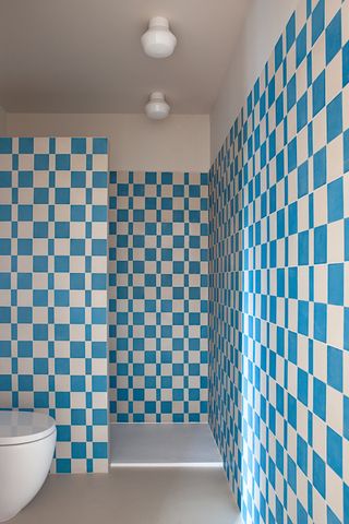 A small bathroom with white and blue tiles
