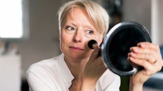 woman putting makeup on