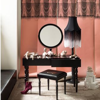 black dressing table with black seat and pink wall