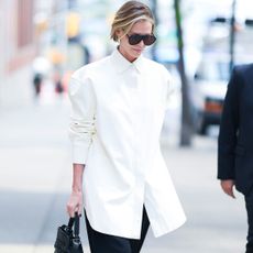 Charlize Theron wearing an oversize tuxedo shirt and black barrel pants