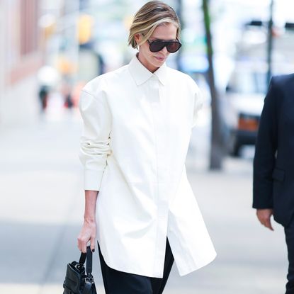 Charlize Theron wearing an oversize tuxedo shirt and black barrel pants