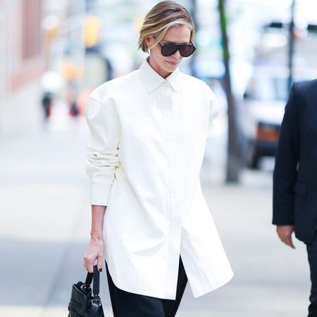 Charlize Theron wearing an oversize tuxedo shirt and black barrel pants