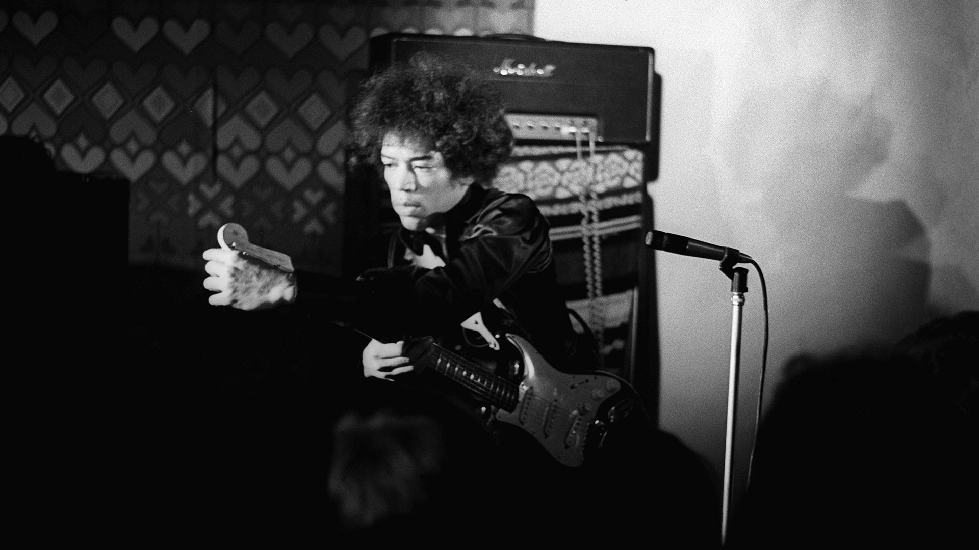 Jimi Hendrix, adjusting his tuning onstage