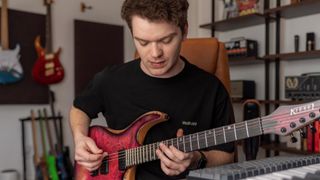 Nick Broomhall playing a red Kiesel guitar