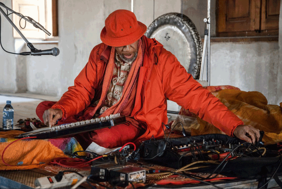 new age musician laraaji dressed in orange and performing at Grace Wales Bonner's 'Devotional Sounds'