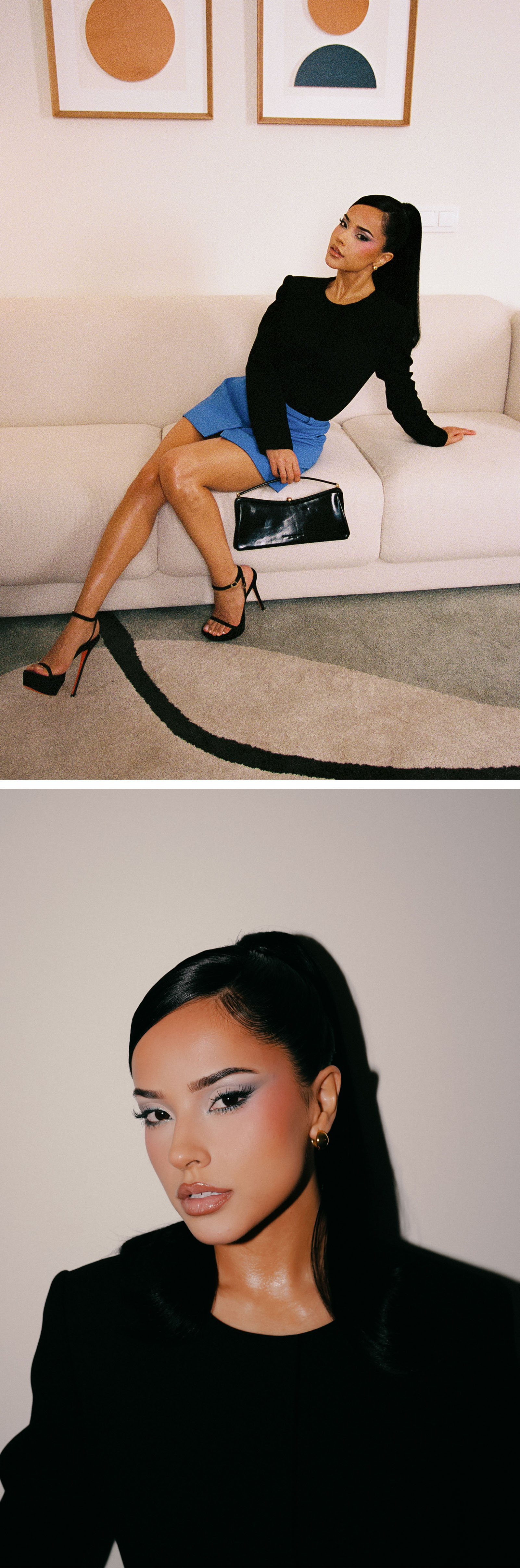 Becky G sitting on on a white couch. She is wearing a black long-sleeve top and blue skirt paired with a black shoulder-strap bag and Christian Louboutin platform heels.