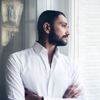 Portrait of a male wearing a white shirt looking out of the window