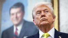 President Donald Trump with photo of President Ronald Reagan behind him