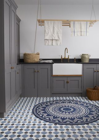 grey laundry room with patterned floor tiles and ceiling drying rack by Carpetright