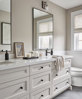 A neutral-toned family bathroom with chevron floor tiles and double sink