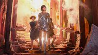 Jadis, in a mirrored minidress, shoulder armour and silver knee boots, strides down steps out of an explosion in a crumbling, rose-red palace, with Polly and Digory behind her