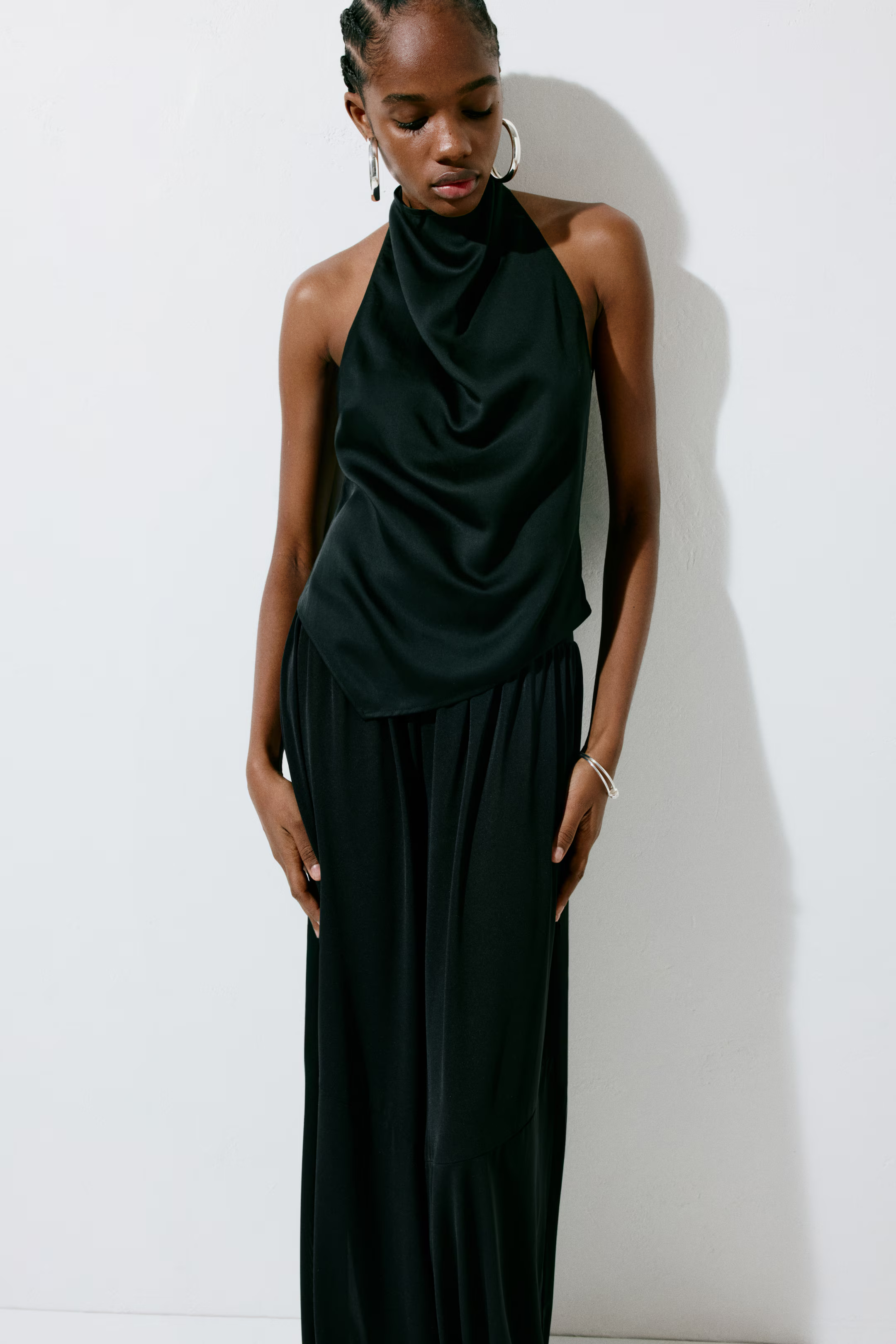 A model wearing a black H&amp;amp;M halterneck top.