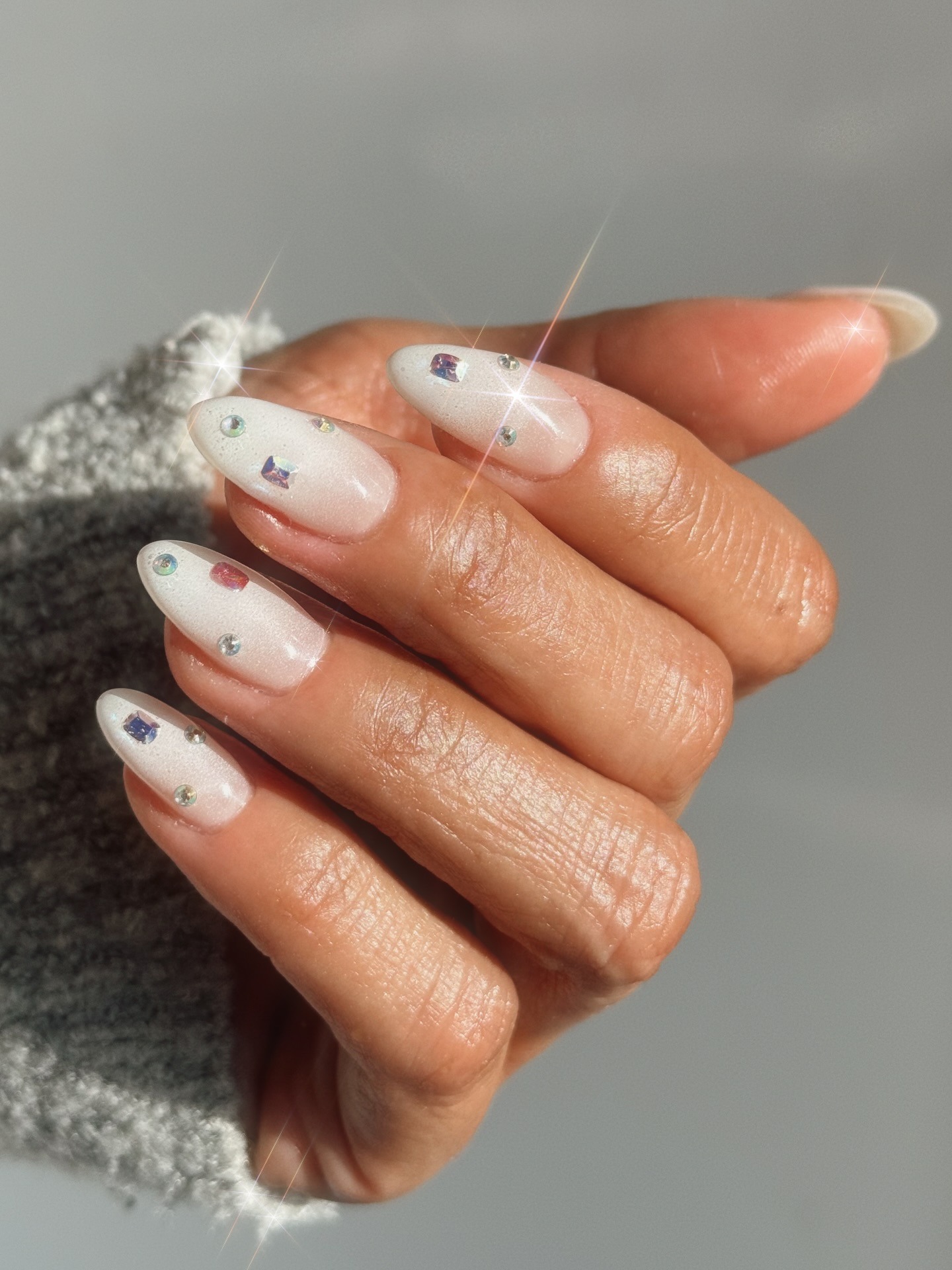 A milky white manicure with silver embellishments