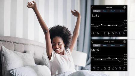 A woman sits up in bed in a brightly lit bedroom with her arms stretched above her head. She looks ready to spring out of bed. Overlaid with inserts of Oura App bedtime and wake-up time graphs over a week