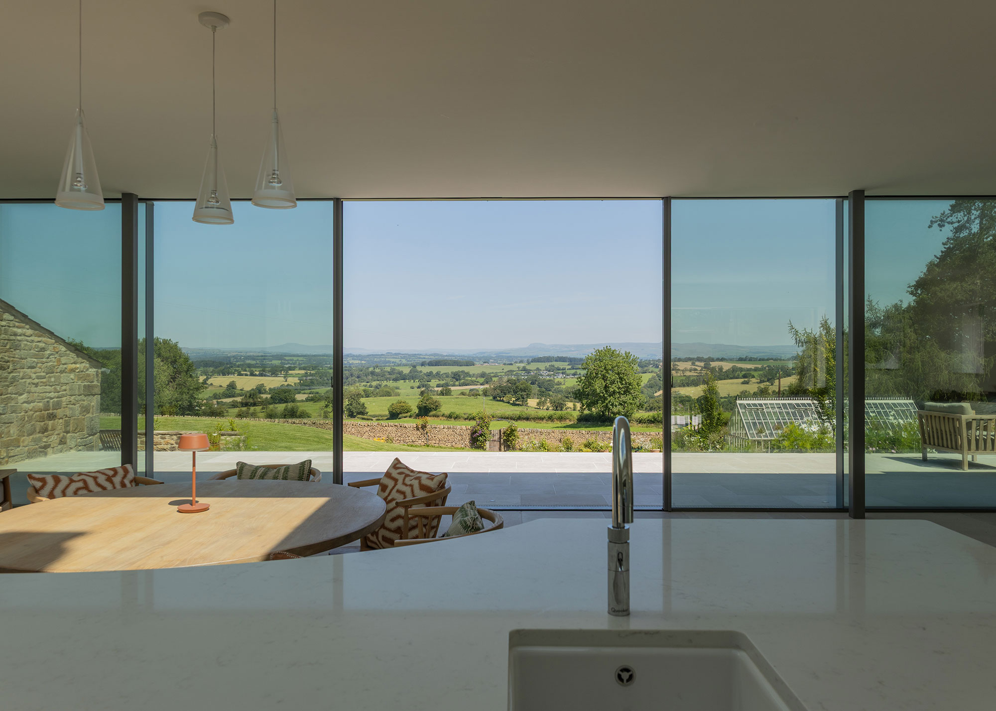 modern kitchen diner with large sliding doors and countryside views