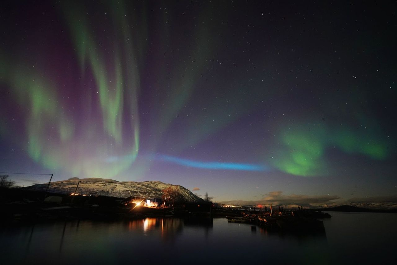 blue ribbon of light appearing over Abisko National Park, Sweden.