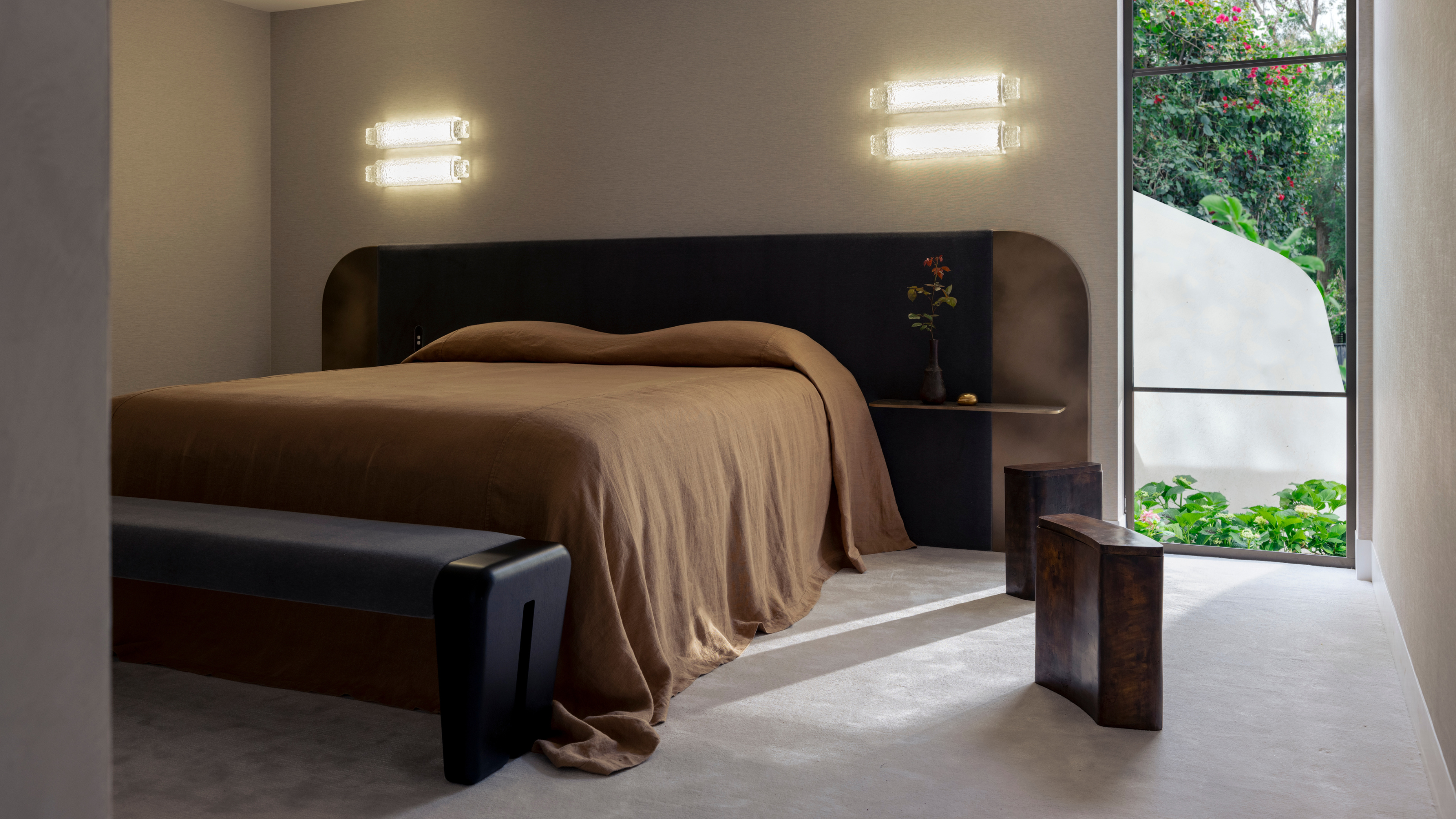 bedroom with a low brown bed and a bench at the end 