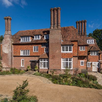 sloping roof house with chimney stack and white windows