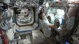 Astronaut Joe Acaba works with cell cultures in the glovebox facility on board the International Space Station.
