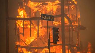 Flames from the Palisades Fire burn a building on Sunset Boulevard amid a powerful windstorm on January 8, 2025