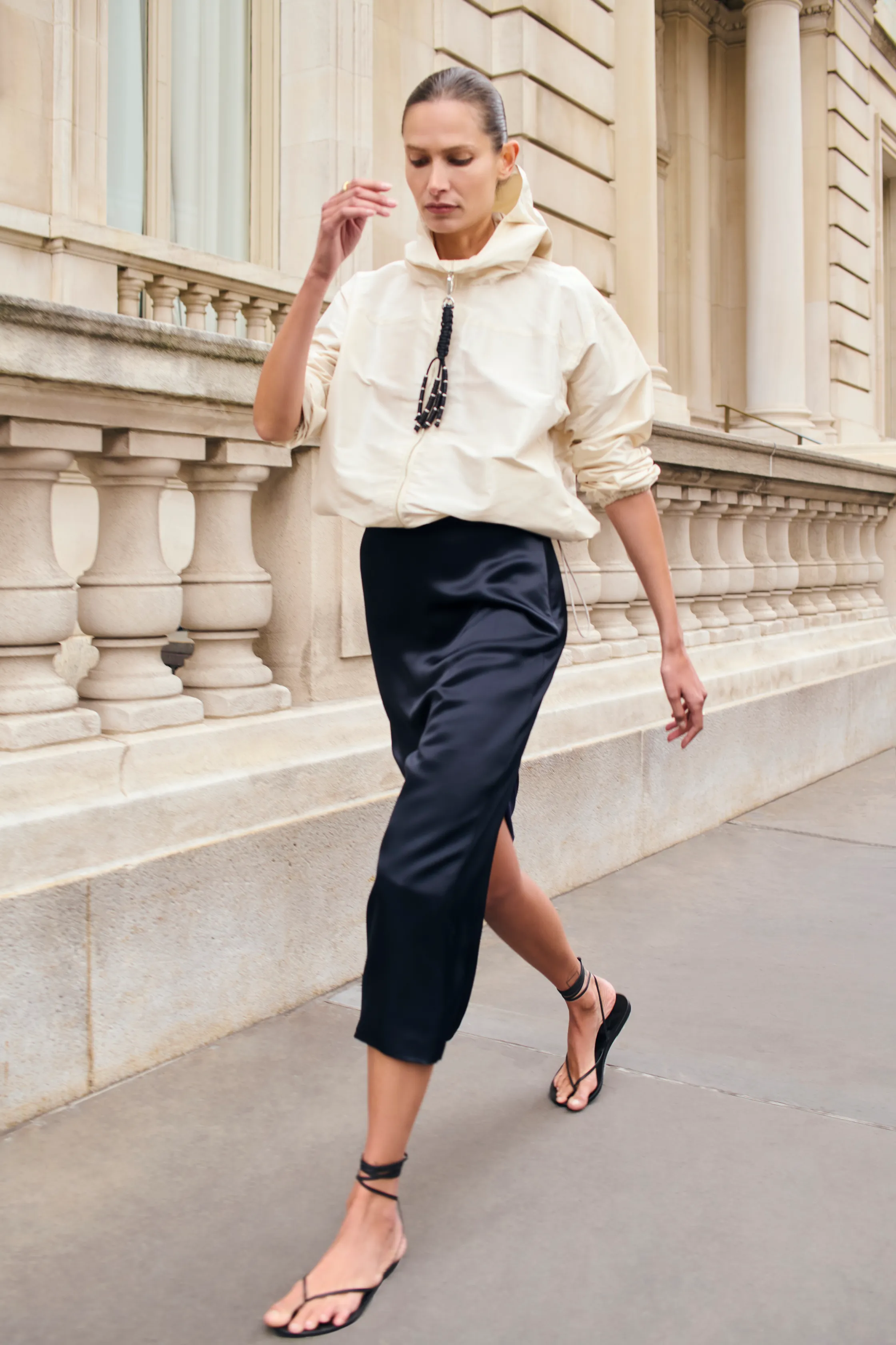 a Kallmeyer Pre Fall 2025 look of a white windbreaker and blue silk skirt