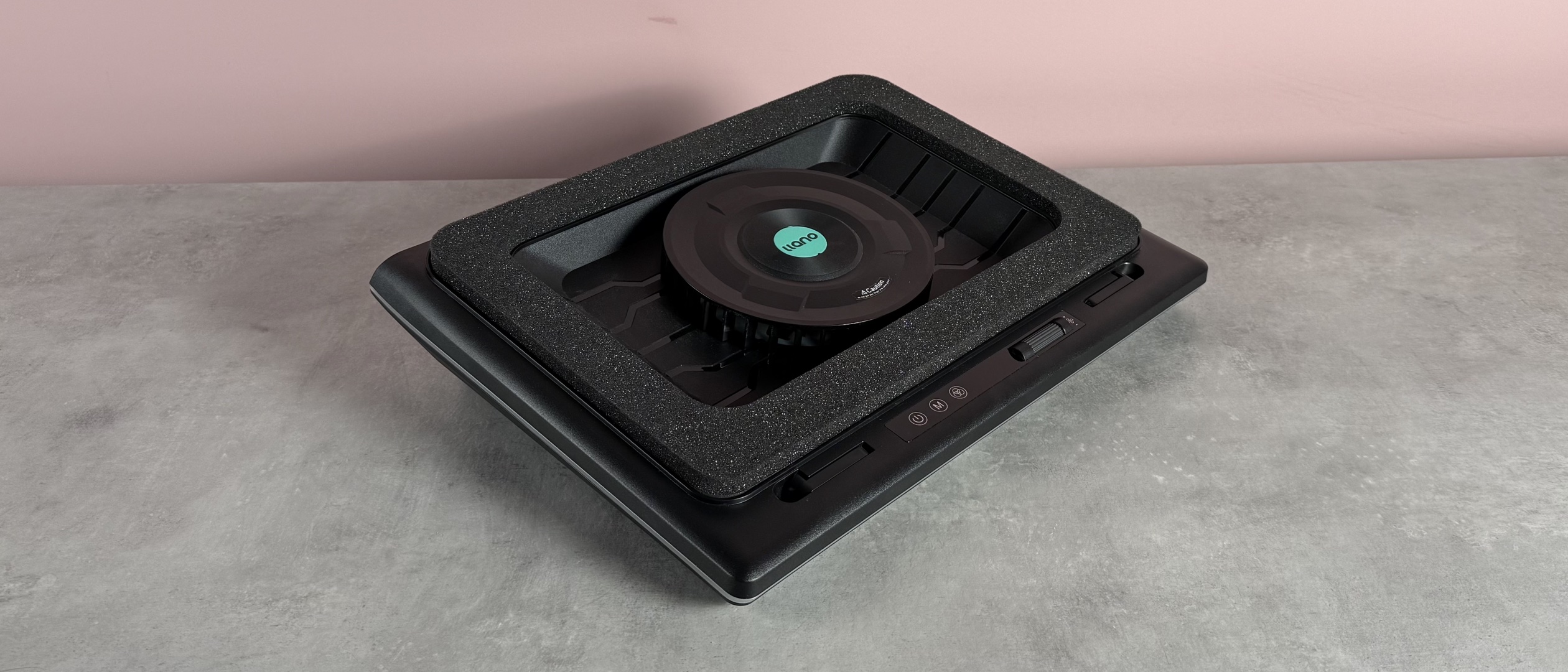 The Llano RGB Laptop Cooling Pad at a 3/4s angle in front of a pink background.