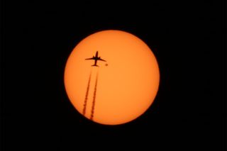 The heart-shaped sunspot AR 2529 sits beneath the wingtip of a plane crossing the sun's face in this photo, which was captured by Alexander Krivenyshev of New York City on April 13, 2016.