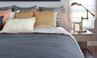 Bed with grey bedding and luxury cushions