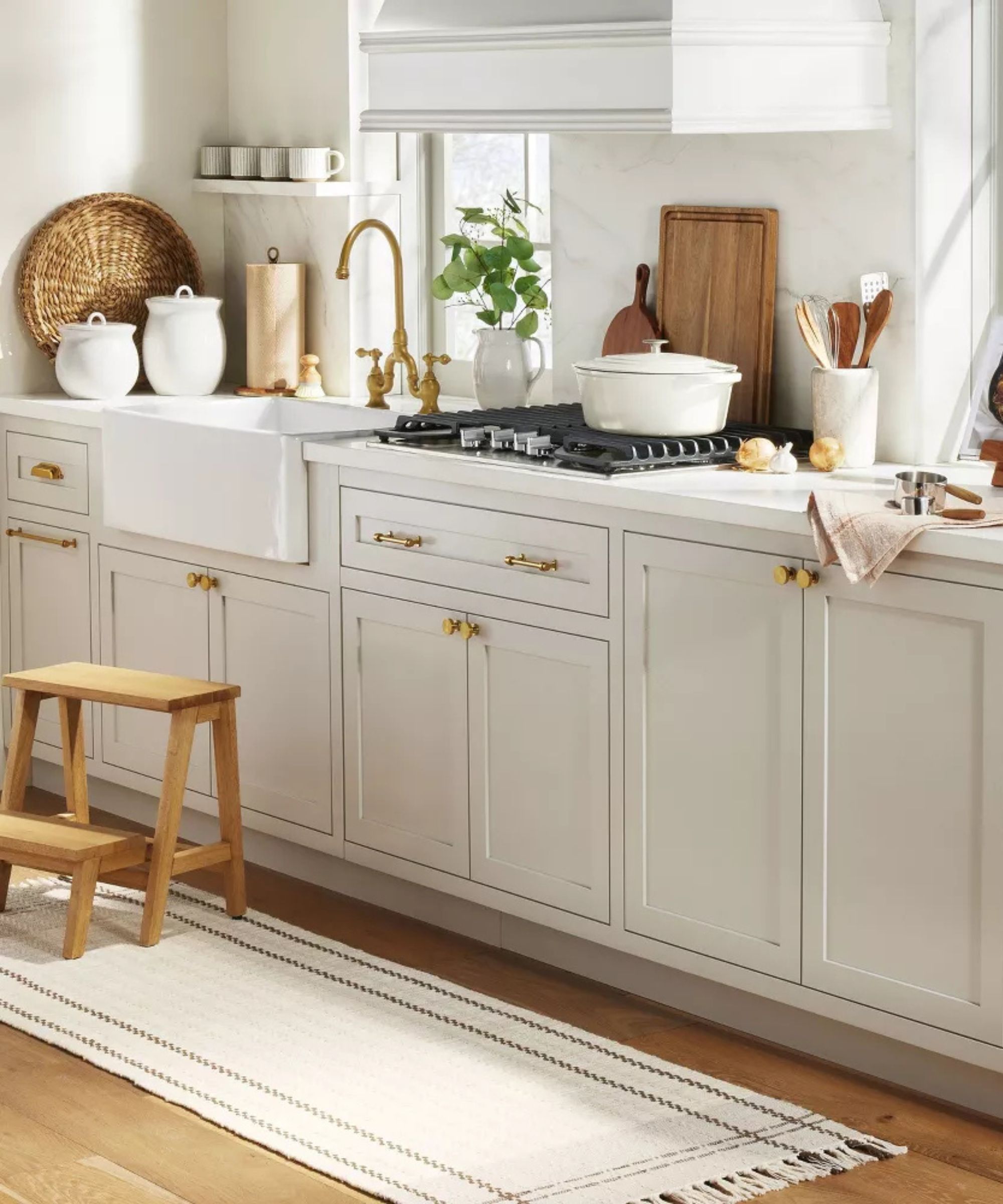 White shaker kitchen with brass hardware and wooden decor