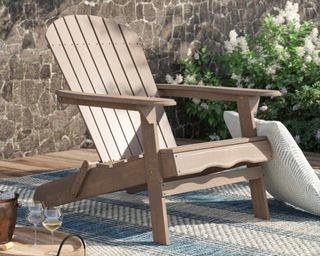 A wooden Adirondack chair on a paved patio