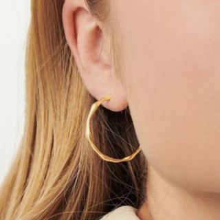 Gold hoop earring shown on model