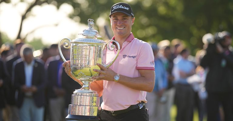Justin Thomas holds a trophy