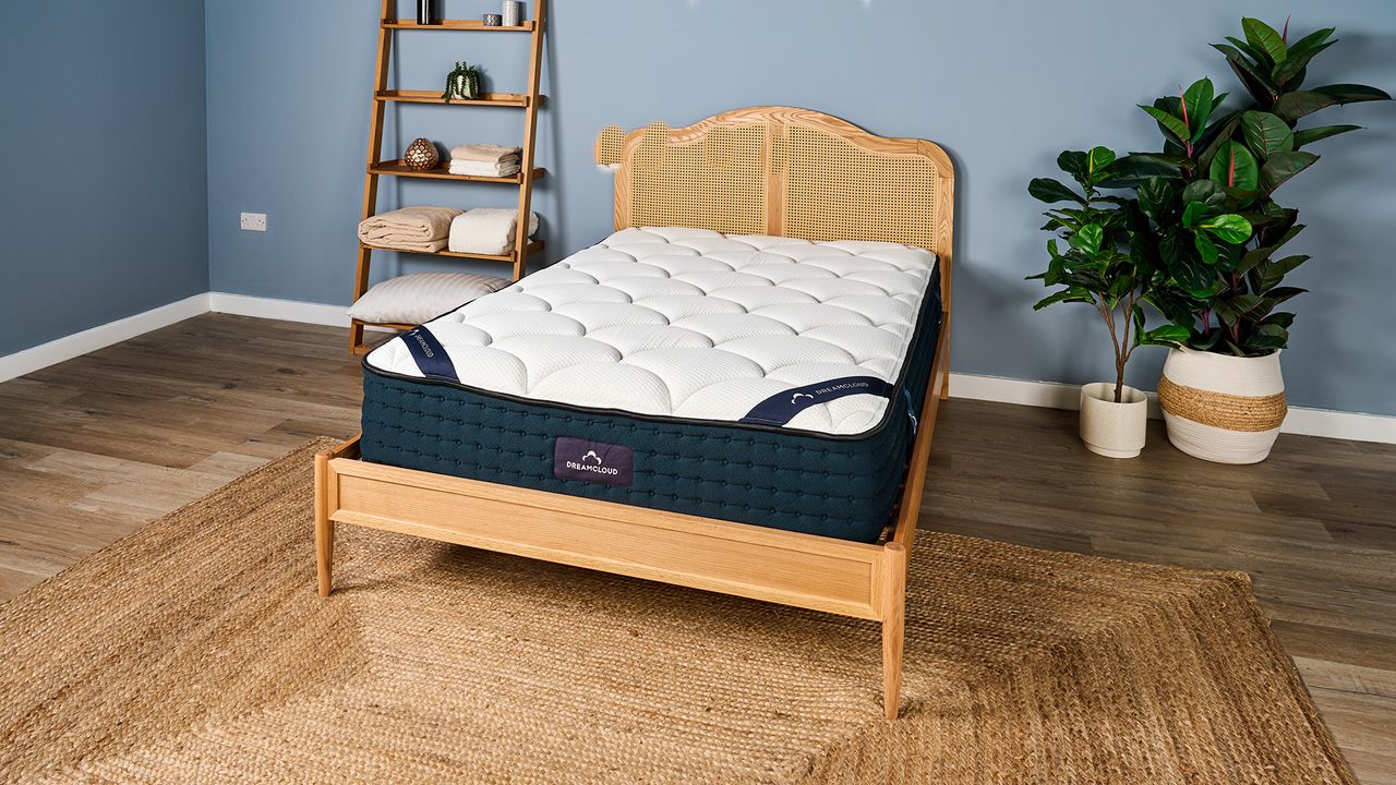 The DreamCloud Luxury Hybrid mattress placed on a rattan bed frame in our Sleep Lab and photographed during our testing phase