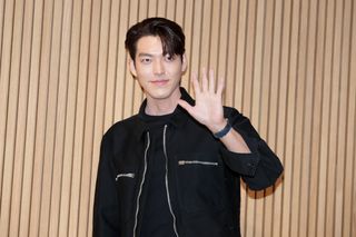 South Korean actor Kim Woo-Bin waves and poses for the media