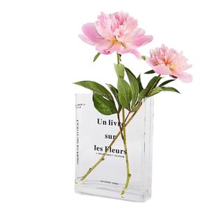 An acrylic book vase with flowers in it